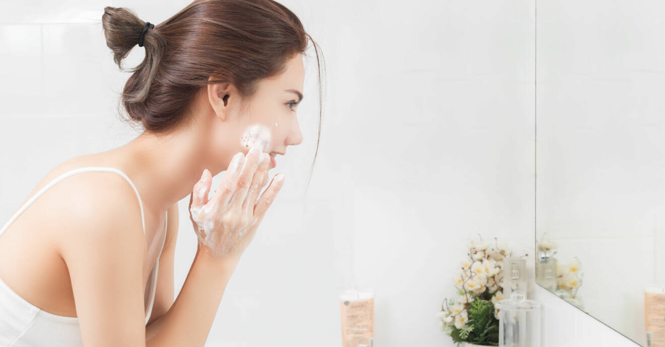 kvinna tvättar ansiktet med rengöring