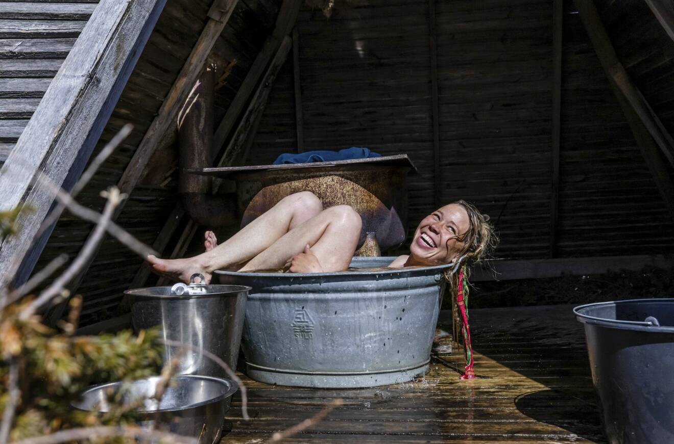 Anna badar och tvättar sig i den lilla zinkbaljan som står i en liten kåta vid sjön.