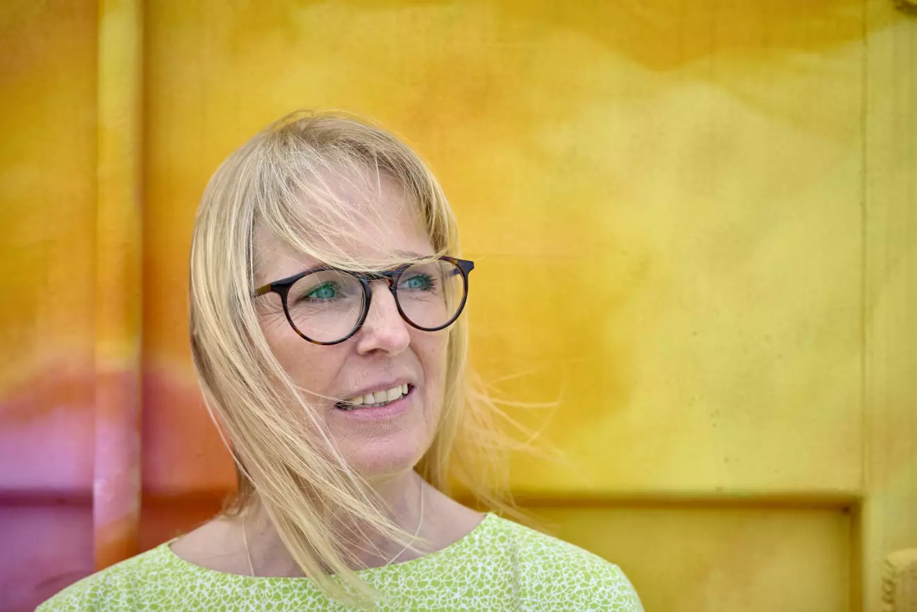 Maria Grönhave, nykter alkoholist, mot en gul vägg.