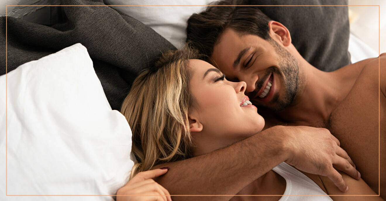 En kvinna och en man ligger i sängen och skrattar