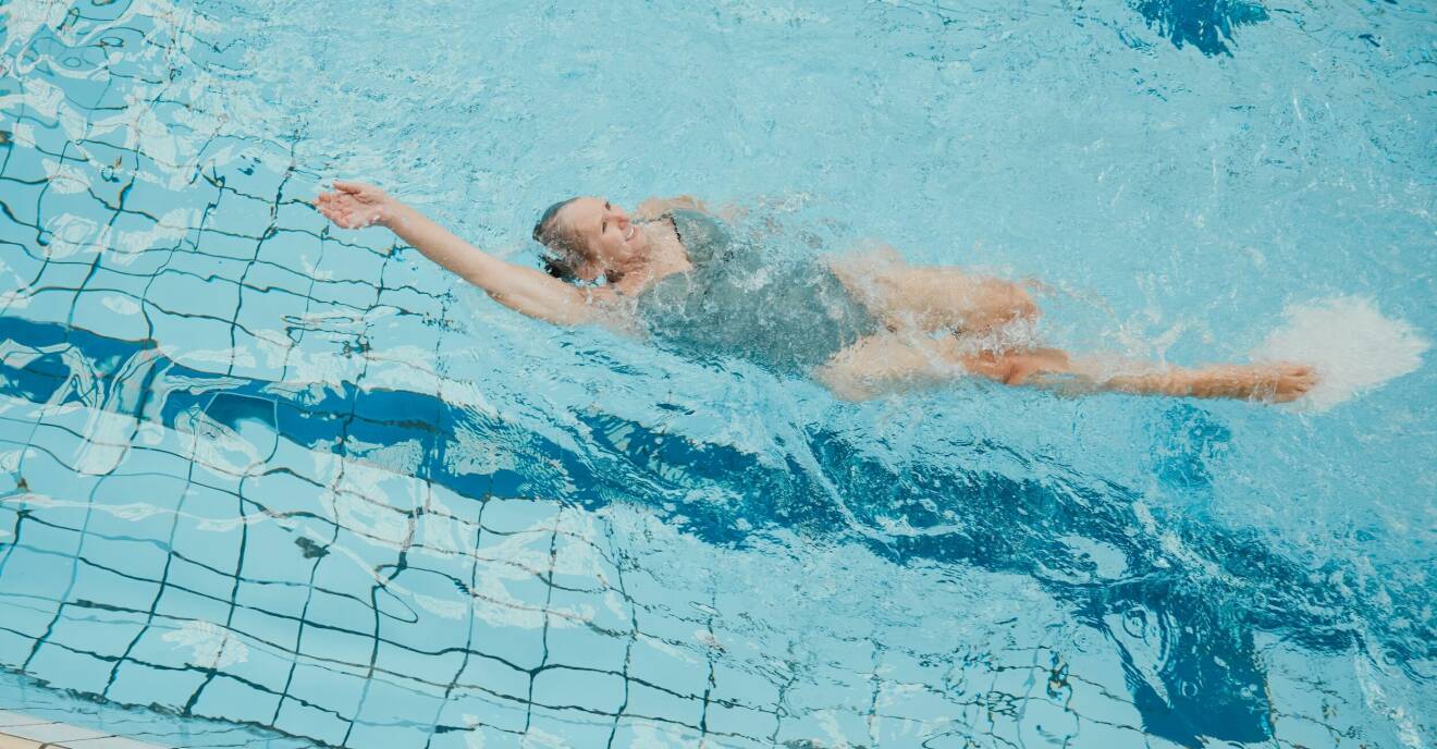 Kvinna simmar i bassäng