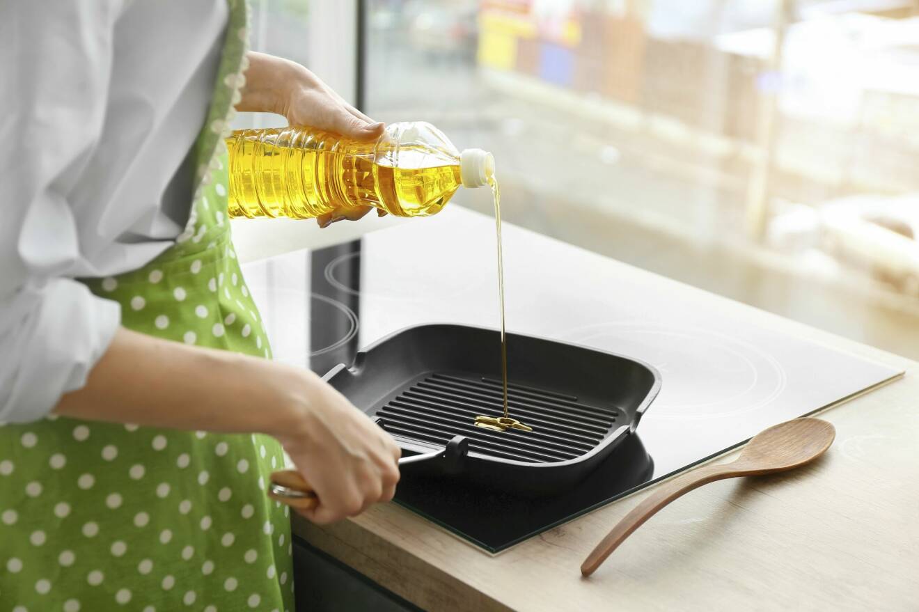 kvinna lagar mat med olja