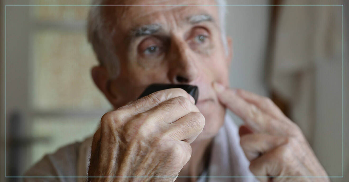 Äldre man rakar sig framför spegeln