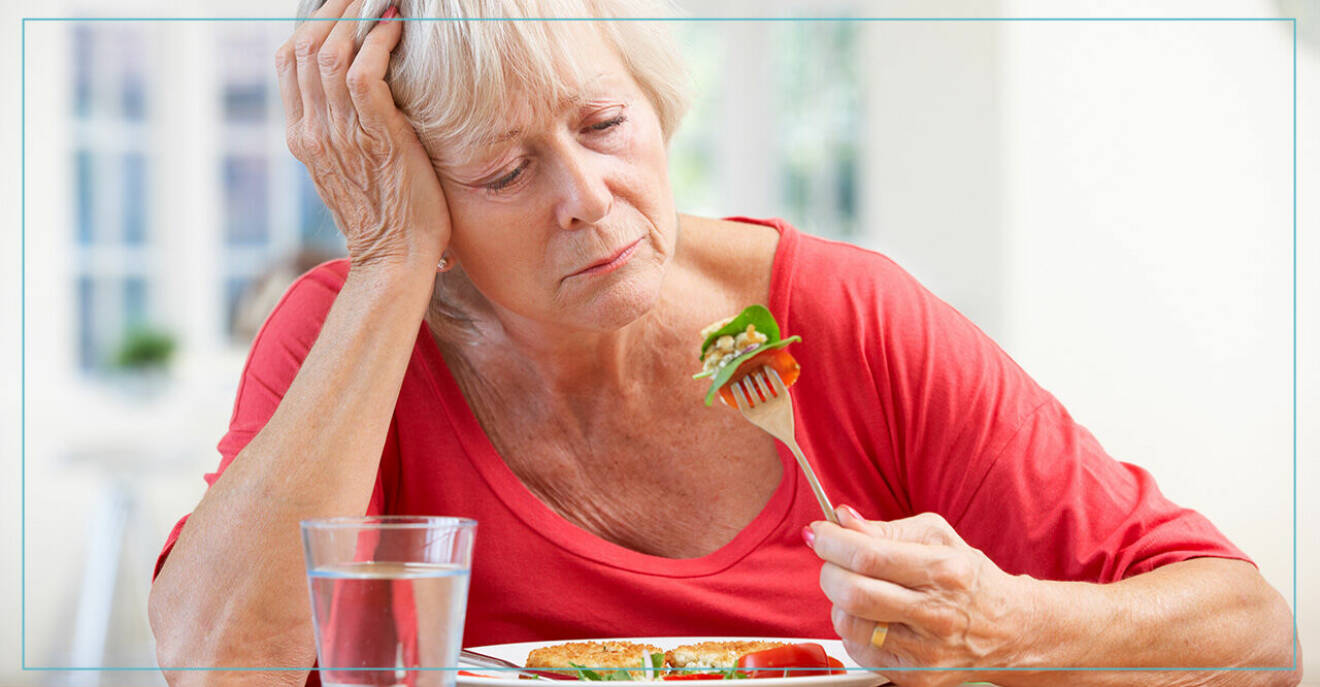 Äldre kvinna tittar olyckligt på gaffeln med mat