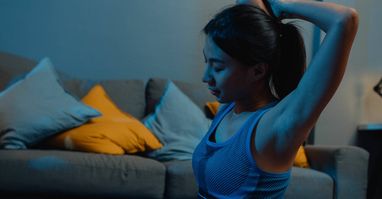 Kvinna gör yoga i ett mörkt rum