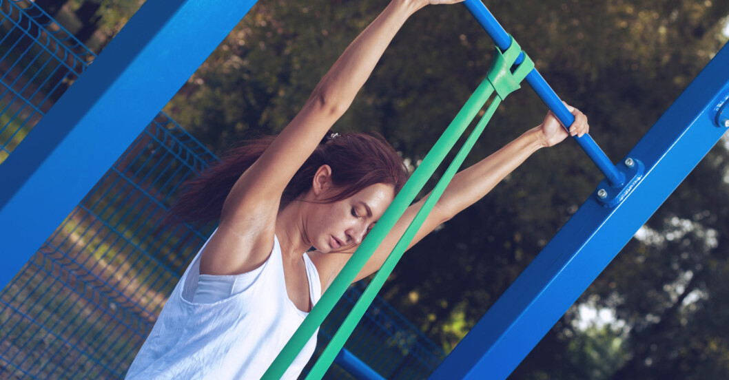 Gummiband kan vara till hjälp när man behöver lite extra stöd i träningsövningar. Kvinna använder gummiband till pull ups och chins