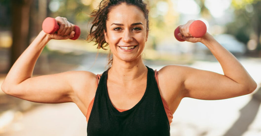 Testa att göra dina burpees med hantlar i händerna. kvinna gör burpee-variant med hantlar