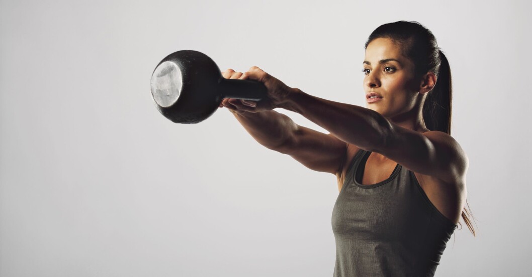 Kettlebellswingar är effektiv träning som kopplar in många muskler i kroppen. kvinna gör kettlebellswingar