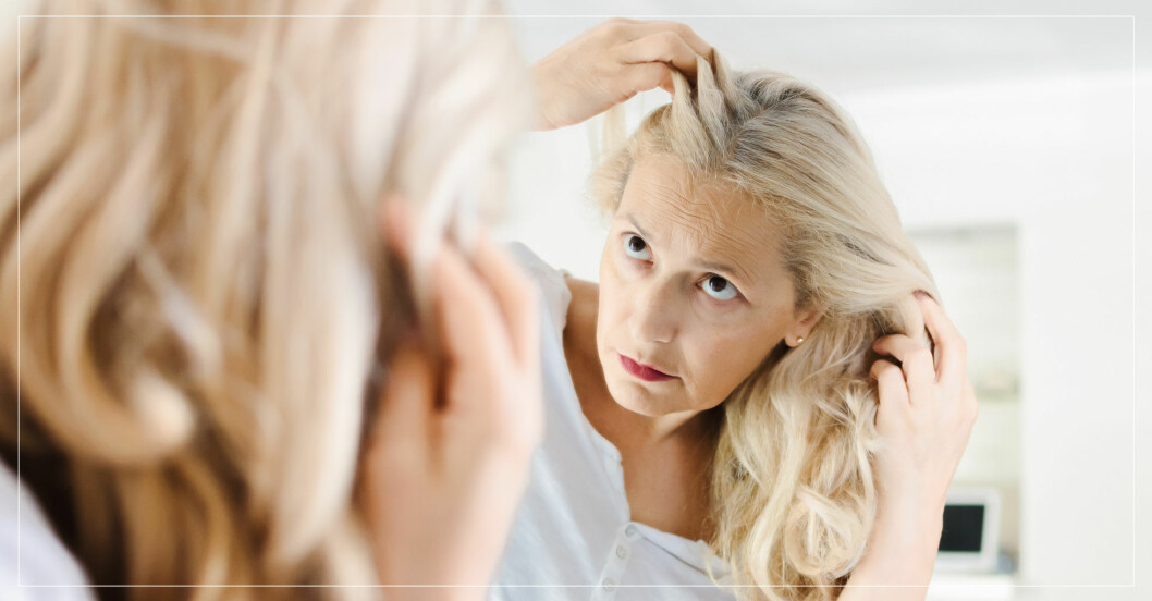 Kvinna tittar på sitt hår i en spegel.