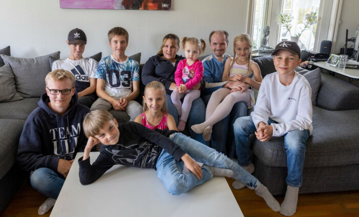 Linda Bergsängel med maken Patrik Bergsängel och alla åtta barn. Linda, som blev blind efter en misslyckad operation, sitter i en soffa tillsammans med sin man och deras åtta barn.