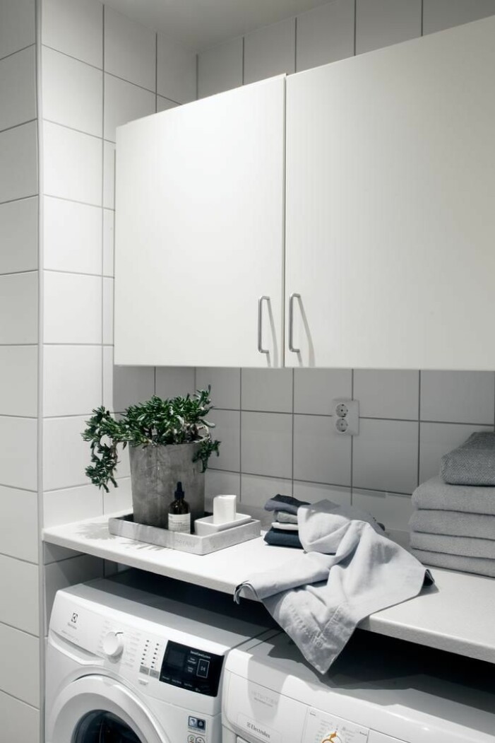 Ett rymligt badrum med både tvättmaskin och torktumlare.