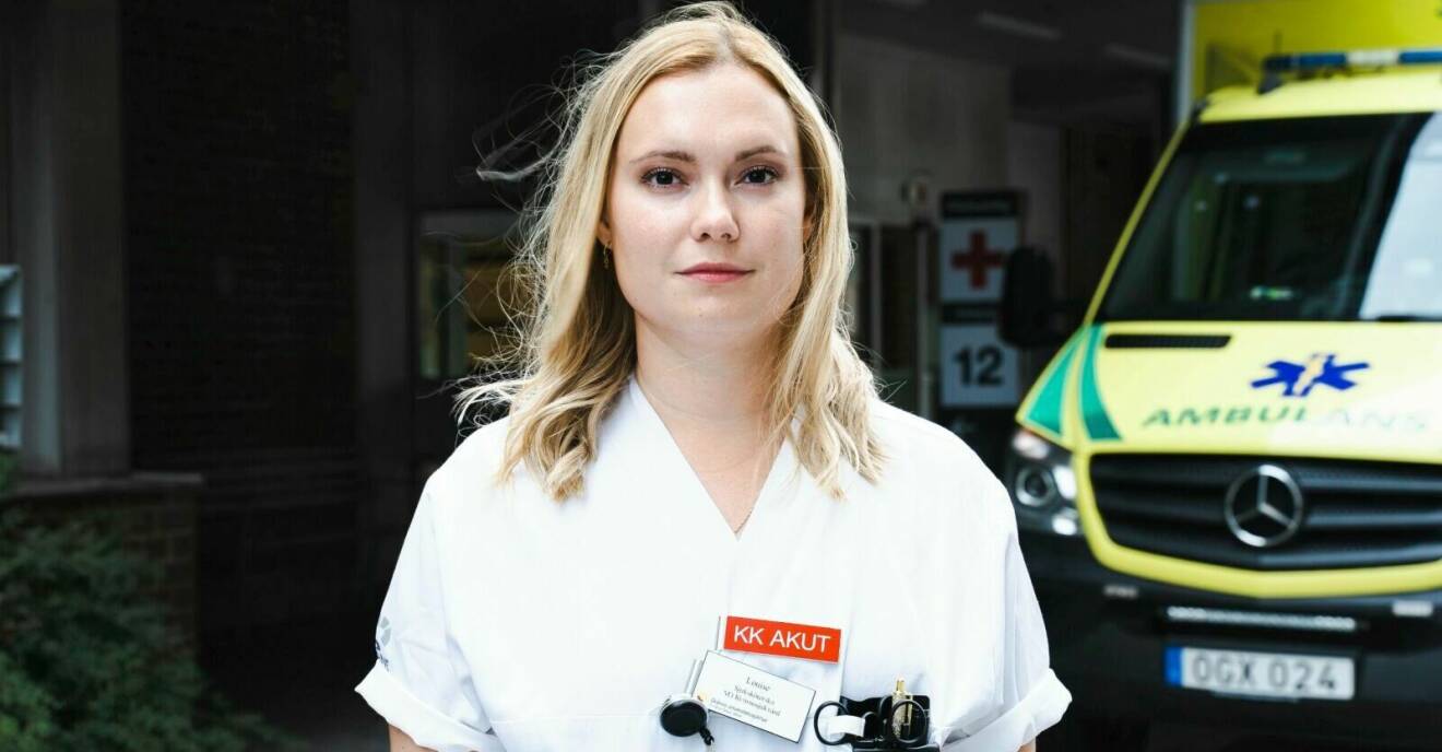 Louise Frank i sjuksjöterskeuniform med en ambulans i bakgrunden.