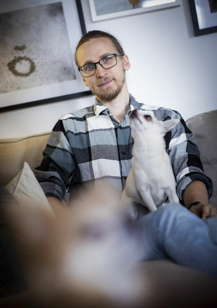 När Mikael sa till Linda att han gillade att klä sig i kvinnokläder fick han fri tillgång till hennes garderob. En man i 40-årsåldern i rutig skjorta och glasögon sitter i en soffa med en chihuahua i knät.