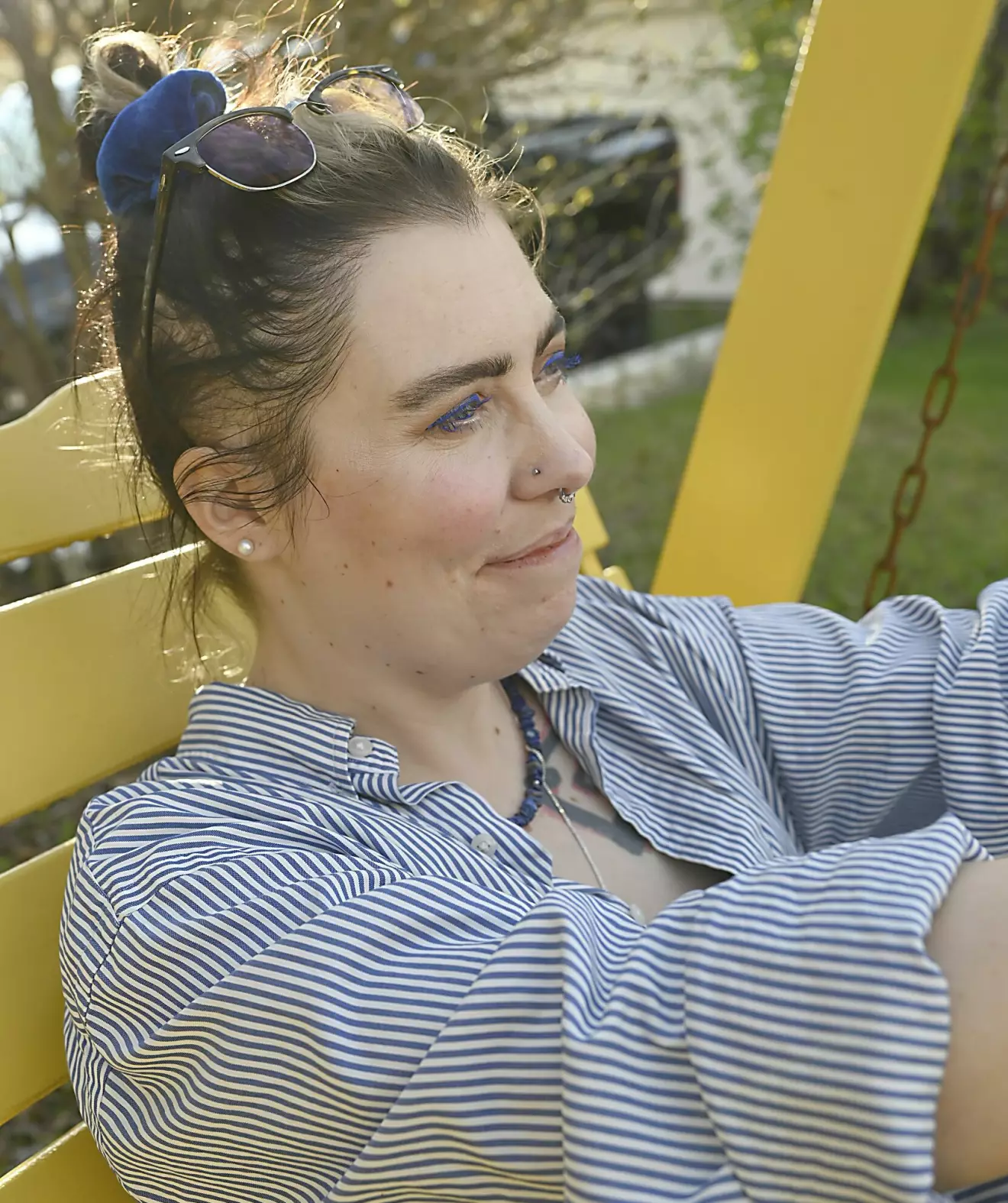 Moa sitter på en parkbänk och ler.