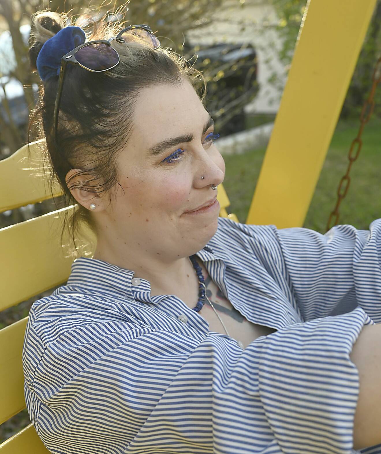 Moa sitter på en parkbänk och ler.