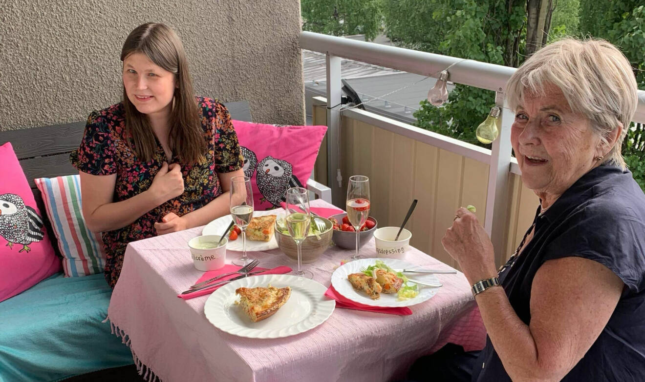 Lisa och Mona äter middag på balkongen.