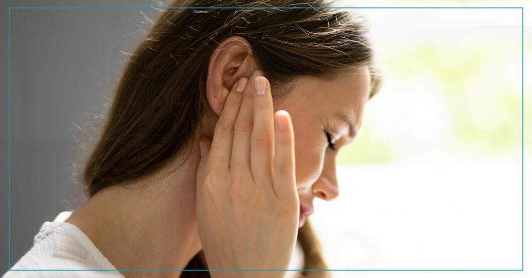 Kvinna med öronlock och smärta håller sig för högerörat