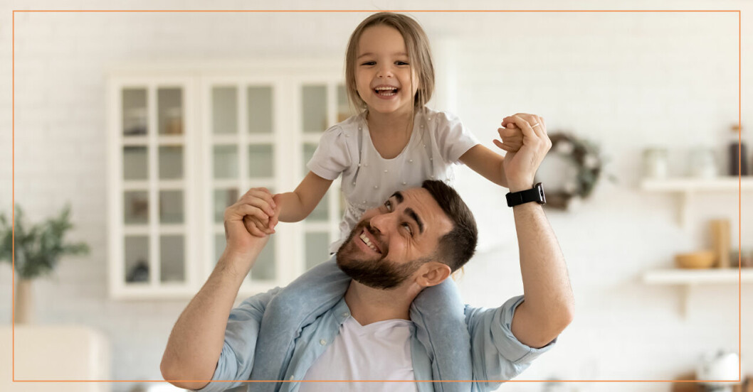 En pappa och en dotter som sitter på axlarna