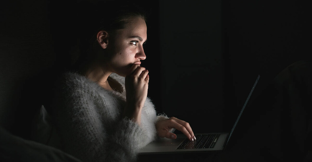 Kvinna som är psykopat kollar på dator i natten