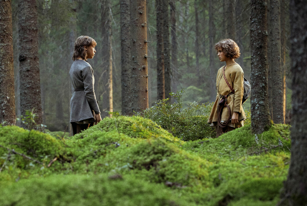 Birk och Ronja möts i skogen. Jack Bergenholtz Henriksson och Kerstin Linden i skogen i Ronja
