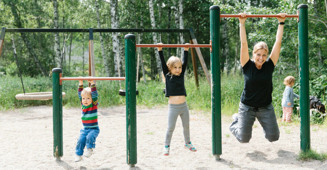 Mamma som tränar med sina barn i en lekpark