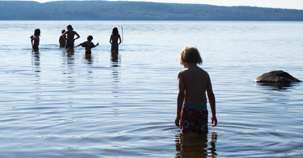 Barn som badar i en sjö.