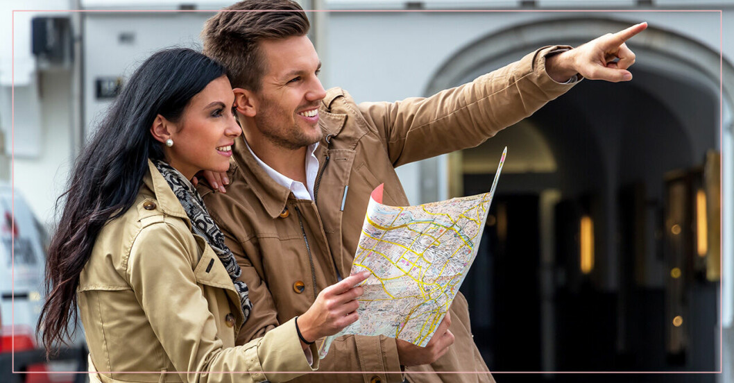 Par som tittar på en analog karta istället för telefonen.