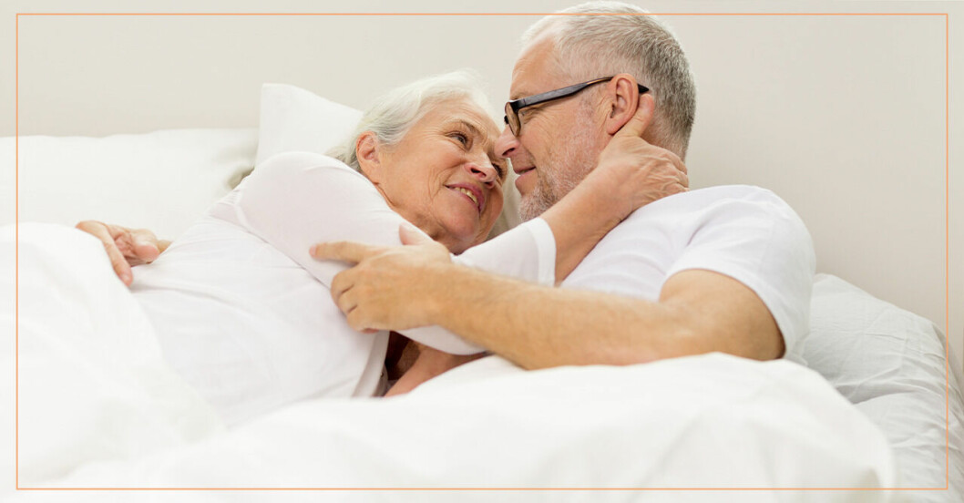 Äldre par ligger i sängen och håller om varandra