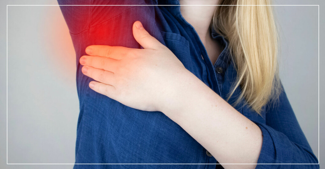 Kvinna som har ont i armhålan av en svullen lymfkörtel.