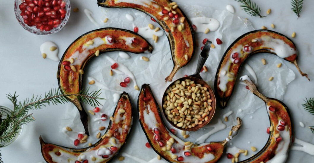 Ugnsbakad banan på bord med pinjenötter och granatäppelkärnor.
