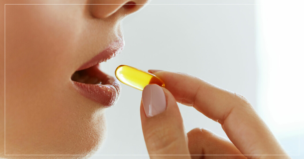 kvinna stoppar vitaminpiller i munnen