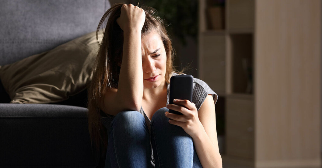 Orolig kvinna söker information på sin mobil